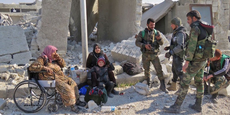Quattro combattenti fedeli ad Assad insieme a un bambino e due donne residenti nel quartiere Sheikh Saeed di Assad, prima sotto il controllo dei ribelli 
(STRINGER/AFP/Getty Images)