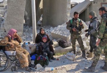 Quattro combattenti fedeli ad Assad insieme a un bambino e due donne residenti nel quartiere Sheikh Saeed di Assad, prima sotto il controllo dei ribelli 
(STRINGER/AFP/Getty Images)