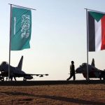 Military personnel walk past the flags of Saudi Arabia and Sudan as Sudan's President Omar Ahmed al-Bashir attends the final training exercise between the Saudi Air Force and Sudanese Air Forces at Merowe Airport in Merowe, Northern State, Sudan April 9, 2017. REUTERS/Mohamed Nureldin Abdallah - RTX34SBQ