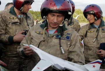 FILE - In this Tuesday, Aug. 16, 2005 file photo, wearing a flying gear Russian President Vladimir Putin holds his souvenir, a mock-up of a supersonic Tu-160 strategic bomber, at an airfield near the northern city of Murmansk, Russia, shortly after landing there aboard a Tu-160, with the bomber crew in the background. Russias defense minister says the military will conduct regular long-range bomber patrols, ranging from the Arctic Ocean to the Caribbean and the Gulf of Mexico. (AP Photo/ITAR-TASS, Presidential Press Service, Alexei Panov)