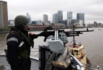 [LONDON, ENGLAND - MAY 04: A sailor stands guard at the bow of the Royal Navy Helicopter Carrier HMS Ocean as she makes her way up the River Thames as part of security rehearsals ahead of the London 2012 Olympics, on May 4, 2012 in London, England. The exercise is aimed at testing military capabilities to ensure operational readiness before the start of the Olympic Games. (Photo by Oli Scarff/Getty Images)] *** [] ** TCN OUT **