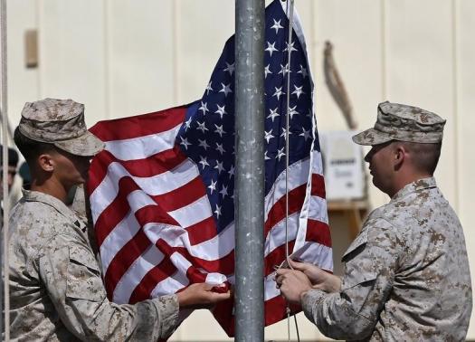 U.S. Marines lower their flag during a handover ceremony, as the last U.S. Marines unit and British combat troops end their Afghan operations, in Helmand October 26, 2014.  REUTERS/Omar Sobhani
