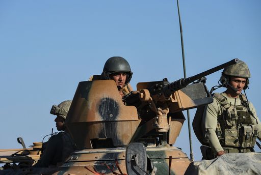 TOPSHOT - Turkish soldiers stand in a Turkish army tank driving back to Turkey from the Syrian-Turkish border town of Jarabulus on September 2, 2016 in the Turkish-Syrian border town of Karkamis. Turkish military experts on September 1, 2016 cleared mines from the area of the Syrian town of Jarabulus captured from jihadists last week, using controlled explosions that sent clouds of dust and smoke into the sky, an AFP photographer said. Pro-Ankara Syrian rebels, backed by Turkish aviation and tanks, took Jarabulus from Islamic State (IS) fighters in a lightning operation and now enjoy full control of the town. / AFP PHOTO / BULENT KILIC