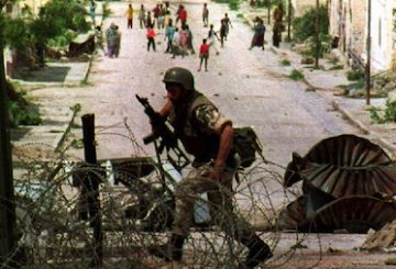 MOGADISHU, SOMALIA: An U.N. soldier runs towards a U.N. checkpoint 08 July 1993, near "villa Somalia," the residence of ex-Somali dictator Syad Barre. A U.N. spokesman denied reports 08 July that 2,00 extra U.S. troops had been deployed in Somalia. (Photo credit should read ERIC CABANIS/AFP/Getty Images)