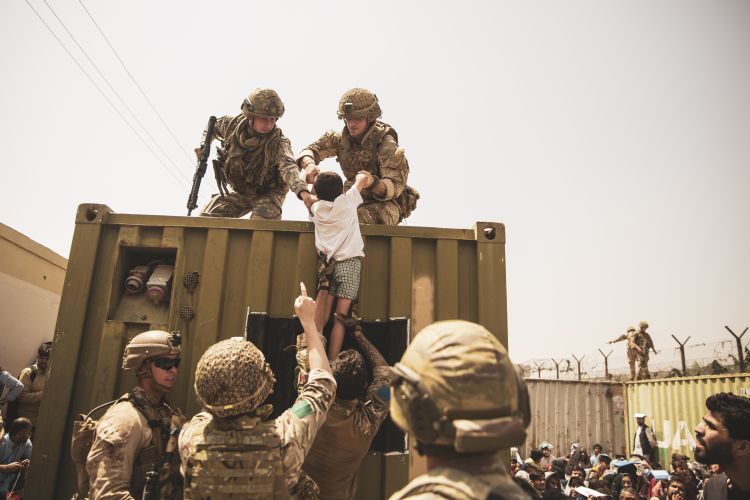 UK coalition forces, Turkish coalition forces, and US Marines assist a child during an evacuation at Hamid Karzai International Airport, Kabul, Afghanistan 200821 CREDIT US DEPARTMENT OF DEFENSE