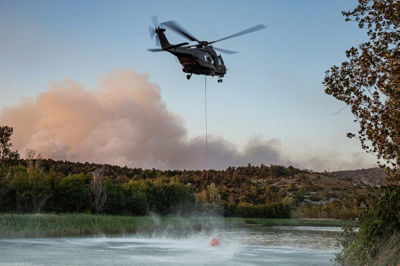 Elicottero UH-90 in fase di prelevamento acqua da un lago per la lotta agli incendi boschivi